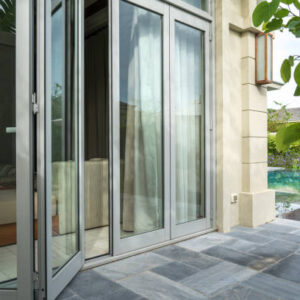 Open window in tropical villa. Summer garden with green leaves on foreground