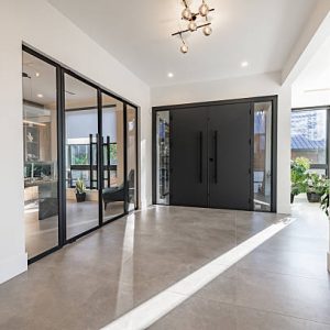 A very large modern contemporary private residence residential home spacious interiors living room, kitchen, office, recreation room, foyer, hallway, floating staircase window wall open to a patio with BBQ and swimming pool. New construction family home