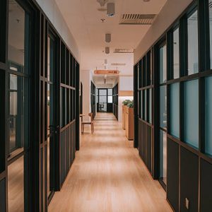 Contemporary office hallway featuring frosted glass walls, clean design, and natural lighting. The space reflects modern workplace architecture, offering a professional environment. Kuala Lumpur, Malaysia.