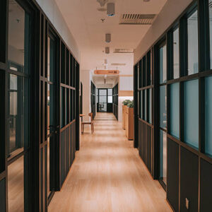 Contemporary office hallway featuring frosted glass walls, clean design, and natural lighting. The space reflects modern workplace architecture, offering a professional environment. Kuala Lumpur, Malaysia.